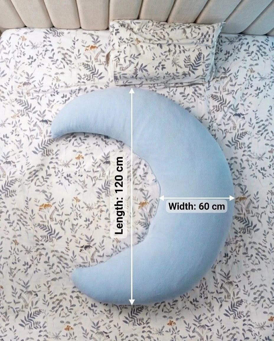 Blue crescent-shaped pillow on a floral-patterned bed with measurements indicated.