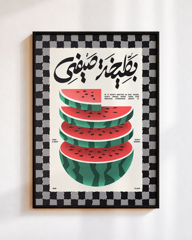 Bateekha poster in a black frame on a white wall: stacked slices of watermelon under the Arabic words بطيخة صيفي, inside a black and white checked border
