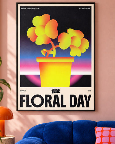 Floral Day poster framed on a pink wall above a blue velvet sofa