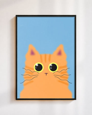 Ginger Cat poster in a black frame on a white wall: a ginger tabby cat with big round eyes on a sky blue background
