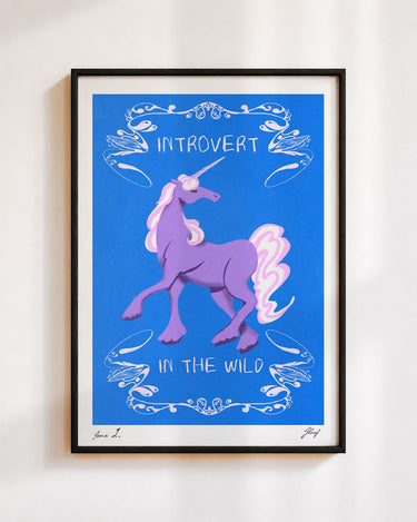 Introvert in the Wild poster in a black frame on a white wall: a lilac unicorn inside white swirls on cobalt blue, with the words Introvert in the Wild