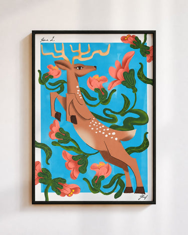 Leaping Deer poster in blue, in a black frame on a white wall: a spotted deer leaping through coral flowers and green vines on a sky blue background
