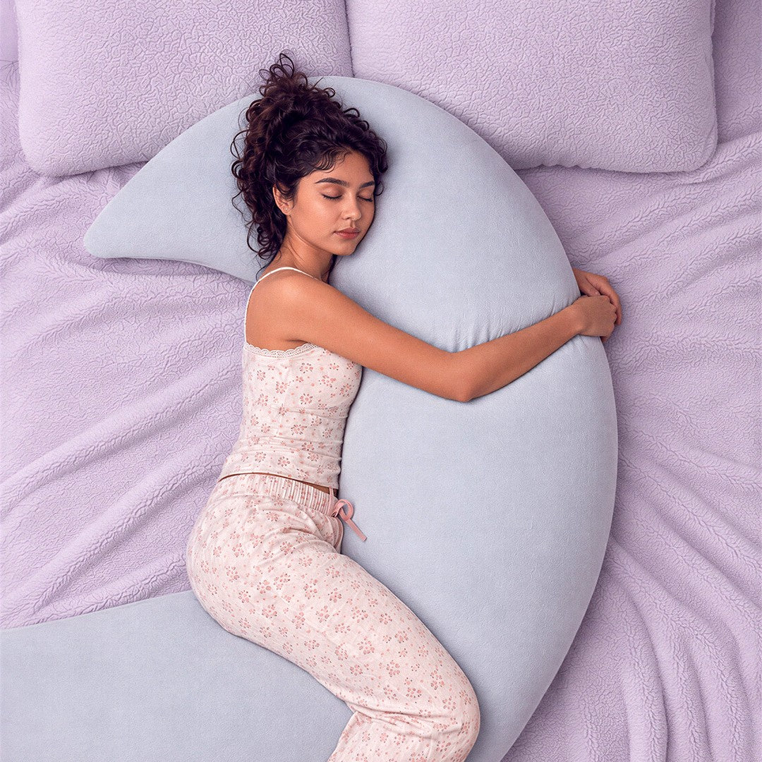 Someone asleep hugging the baby blue Floof Body Pillow on a lilac bed