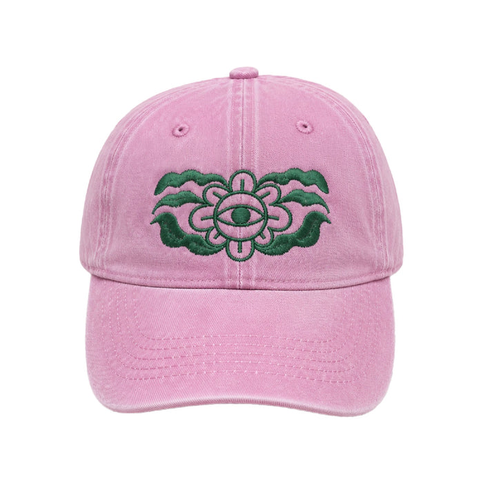 Washed pink cap with a dark green embroidered flower with an eye at its centre