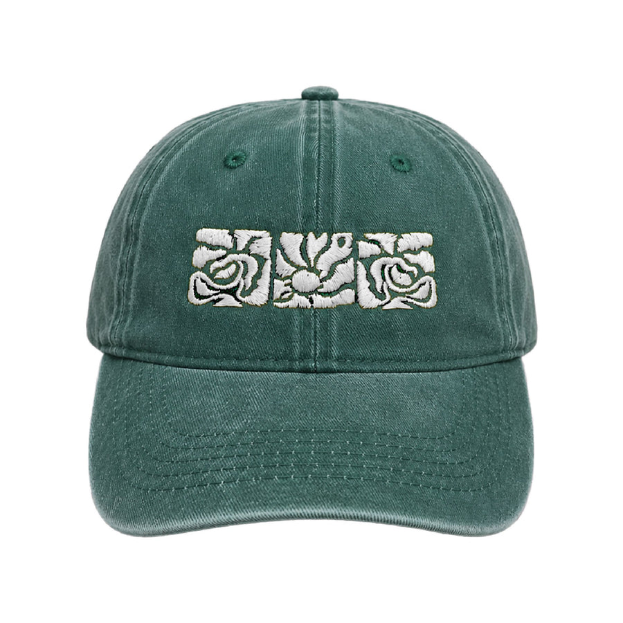 Deep pine green cap with three white embroidered rose tiles across the front