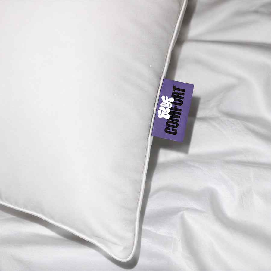 Close-up of the purple Floof Comfort tag on the corner of the white pillow