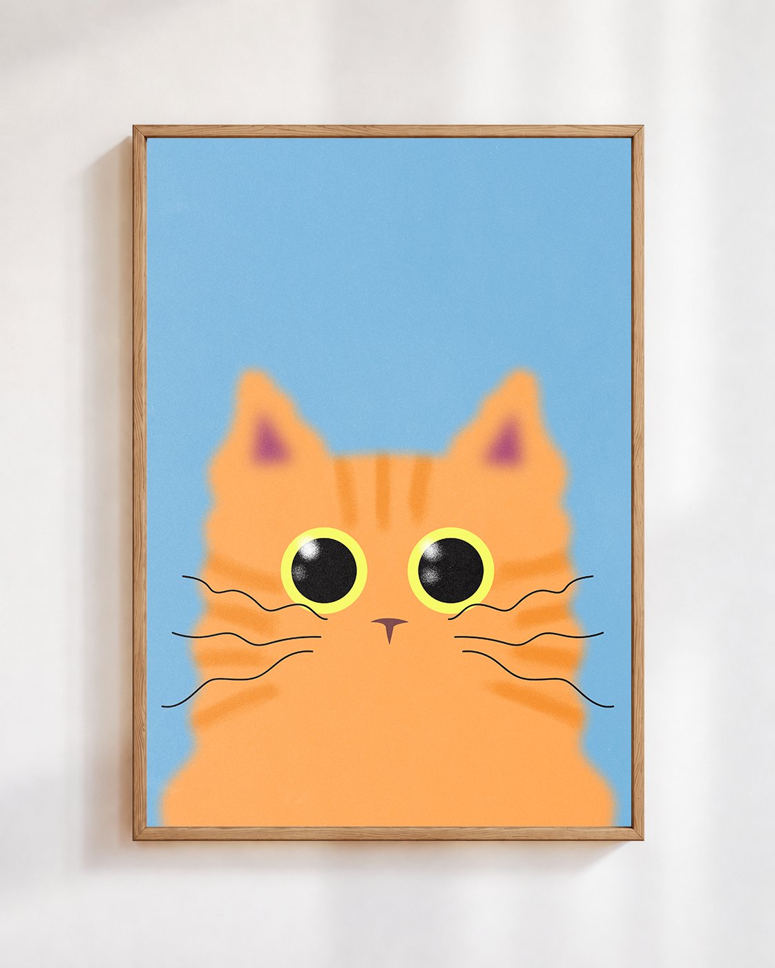 Ginger Cat poster in a wooden frame on a white wall: a ginger tabby cat with big round eyes on a sky blue background