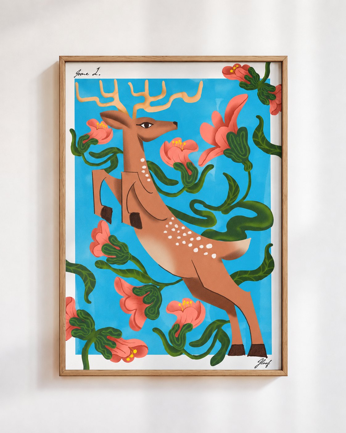 Leaping Deer poster in blue, in a wooden frame on a white wall: a spotted deer leaping through coral flowers and green vines on a sky blue background