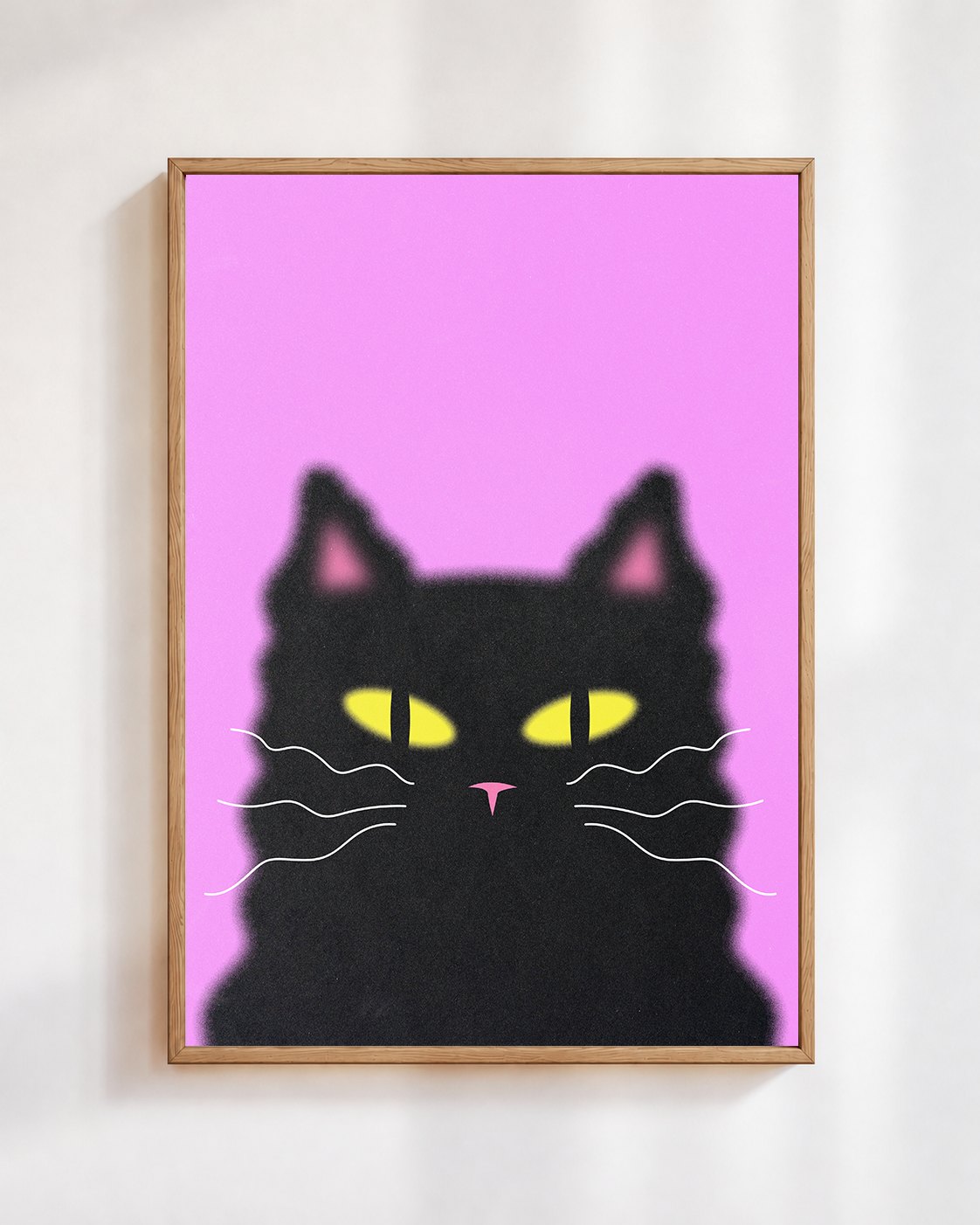 Midnight Cat poster in a wooden frame on a white wall: a fluffy black cat with yellow eyes on a hot pink background